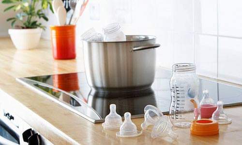 VỆ SINH BÌNH SỮA ĐÚNG CÁCH
----------------------------------
 
Khử trùng bình sữa như thế nào?
 
Khi sử dụng bình  sữa lần đầu tiên thì trước hết bạn phải khử trùng nó. Cách khử trùng bình sữa khá đơn giản. Đầu tiên bạn phải rửa sạch bình bằng nước xà phòng. Đổ một lượng nước vừa đủ vào bồn rửa bát , cho một ít nước rửa chén vào nước. Sau đó, cho tất cả bình sữa vào nước và  dùng cọ cọ thật sạch.
Tiếp theo, đun sôi bình sữa trong khoảng từ 5-10 phút. Bạn nhớ là phải đổ nước ngập bình sữa nhé. Sau đó vớt bình ra và đặt vào một nơi thật sạch sẽ cho tới khi khô hẳn.

Những điều cần lưu ý

Khi cho bé bú bình xong, bạn hãy rửa qua bình bằng nước lạnh, Sử dụng cọ thân dài cọ những ngóc ngách của chiếc bình thật sạch sẽ. Đặc biệt là miệng bình vì đây là nơi vi khuẩn rất hay xâm nhập. Không cho bình sữa vào lò vi sóng để làm nóng sữa. Đun nóng sữa trong lò vi sóng không những làm cho bình sữa bị queo lại mà còn làm cho chất lượng của sữa còn giảm đi. Bạn nên làm nóng sữa trong bình bằng cách đặt cả bình vào trong nước nóng. Để kiểm tra xem độ nóng của sữa đã thích hợp với bé hãy chưa thì bạn có thể nhỏ một vài giọt sữa ra cổ tay.

Không nên bất cẩn

 Có nhiều bà mẹ thường quên không rửa sạch bình sữa sau khi đã cho bé bú khiến cho dưới dáy bính bám một lớp vàng ố trong rất mất vệ sinh. Những lớp hoen ố này rất khó để tẩy rửa ngay cả khi bạn dùng những chiếc cọ tốt nhất. Tuy nhiên vẫn có một cách khá đơn giản để bạn có thể tẩy sạch vết ố này. Đó là cho khoảng 2 muỗng gạo đổ vào trong bình. Sau đó, thêm một chút nước xà phòng và lắc đều bình lên. Những vết hoen ố sẽ bị tẩy đi hoàn toàn và chiếc bình sữa của bé sẽ lấy lại được vẻ sáng đẹp như ban đầu.
 Mới bắt đầu làm mẹ bạn thường bỡ ngỡ trong việc chăm sóc bé và có nhiều câu hỏi liên quan đến việc tiệt trùng bình sữa cho bé.

Câu hỏi cơ bản nhất là “Tiệt trùng bình sữa cho bé – Cần thiết hay không?” .
Đối với trẻ sơ sinh không chỉ có bình sữa mà còn có vô vàn những vật dụng khác cần phải đảm bảo vệ sinh an toàn, ví dụ như: gặm nướu, ti giả, phễu hút sữa mẹ, bát, thìa ăm dặm …. So với cơ thể của trẻ trưởng thành thì trẻ sơ sinh không có hệ miễn dịch nên đòi hỏi việc làm sạch các vật dụng này ở mức độ rất cao “100% vô trùng”, bởi vậy mà người ta đã quen với khái niệm “khử trùng” hay “tiệt trùng”.
Để làm sạch các vật dụng cho bé thì “tiệt trùng”chỉ là giai đoạn cuối cùng sau khi chúng đã được rửa rất kỹ bằng nước sạch. Có quan điểm cho rằng không cần phải tiệt trùng bình sữa cho bé khi bình sữa đã được rửa kỹ bằng xà phòng và được tráng qua bằng nước sôi. Nhưng liệu bạn có đảm bảo thao tác cọ rửa của người chăm sóc bé hay chính nguồn nước nơi bạn ở là sạch tuyệt đối không? Cẩn tắc vô áy náy, phòng còn hơn chống, cơ thế non nớt nhạy cảm của bé cần được bảo vệ 100%, tiệt trùng là giai đoạn cho phép bạn yên tâm về điều đó.
Ở Châu Âu (với điều kiện khí hậu mát mẻ khô ráo và sạch sẽ hơn ở nước mình rất nhiều) mà người ta luôn cẩn thận khuyên cha mẹ chỉ cho con uống từ những cái bình đã được tiệt trùng. Nghĩa là không phải là mỗi ngày 1 lần mà nếu bé uống 5 lần/ngày thì mình cũng phải tiệt trùng cái bình đó 5 lần trước khi cho bé bú.
Xem chừng việc tiệt trùng cho bé là công việc rất nặng nhọc vì bé động đến cái gì thì cái đó phải tiệt trùng, chắng may mà bé đánh rơi cái gặm nướu hay cái thìa xuống đất thì coi như nó đã bị nhiễm bẩn cần phải tiệt trùng lại. Để giảm nhẹ công việc này thì bạn nên chọn phương pháp tiệt trùng tiện lợi và gọn nhẹ nhất.
 “Nên hay không tiệt trùng bằng nước sôi?”
Đây phương pháp cổ điển nhất. Bạn không phải mua sắm gì chỉ cần một nồi hấp có dung tích đủ lớn đun sôi các vật dụng trong thời gian 20 phút. Tuy nhiên, phương pháp này không đơn giản và tiện lợi như mọi người vẫn tưởng. Bạn luôn phải giám sát trong quá trình tiệt trùng. Bình sữa phải được nhúng 100% trong nước, thời gian đun phải đủ 20 phút. Thành nồi thường nóng hơn 100oC, nên nếu bình sữa đặt sát nồi sẽ rất dễ bị nóng chảy, nếu bạn để quên nồi trên lửa, bạn có thể thấy tất cả các vật dụng đều bị bóp méo. Sau khi tiệt trùng nếu không đậy nắp vung kín hay ngâm trong nước quá lâu thì đó là điều kiện để vi khuẩn xâm nhập trở lại.
 Tiệt trùng bằng nước sôi – nhiều vấn đề bất cập
Cuộc sống hiện đại luôn đòi hỏi có nhiều tiện ích để giảm bớt công việc cho bạn, vậy “Phương pháp nào tiệt trùng tiện lợi và có hiệu quả?”.
Có 3 phương pháp đáng tin cậy và đã được minh chứng : tiệt trùng bằng hóa chất, tiệt trùng hơi nước bằng điện và tiệt trùng hơi nước bằng lò vi sóng. Chúng tôi phân tích ưu nhược điểm của từng phương pháp này như sau:
Tiệt trùng bằng hóa chất ít tốn kém nhưng mất thời gian (>30 phút). Thuốc khử trùng dạng viên có mùi thuốc tẩy clo khiến cho bé và bạn cảm thấy khó chịu, làm mất vị thơm ngon của sữa trong bình. Chính vì vậy phương pháp này tuy tiện lợi nhưng ít được sử dụng và không phổ biến ở nước ta.
Máy tiệt trùng hơi nước bằng điện được sử dụng phổ biến nhất. Tất các bình sữa và các vật dụng được đặt ngăn nắp trong bình tiệt trùng, mâm tiệt trùng thường được làm bằng nhôm hoặc inox kết nối với nguồn điện. Với sức nóng bốc hơi từ mâm tiệt trùng ở nhiệt độ cao,100% vi khuẩn sẽ bị tiêu diệt. Thời gian tiệt trùng khoảng từ 8 đến 15 phút. Có thể được tiệt trùng lên đến 6 hoặc 8 bình sữa và các phụ kiện cùng một lúc. Được trang bị với bộ phận ngắt tự động và tiếng bíp, không mất công và thời gian giám sát. Thời gian và nhiệt độ hoàn toàn được khống chế, tuyệt đối an toàn không gây hư hỏng vật dụng cũng như làm phá hủy vật liệu có thể gây độc hại cho bé.
Bình tiệt trùng hơi nước bằng lò vi sóng: là phương pháp tiệt trùng nhanh nhất, tiện dụng và nhỏ gọn dễ mang đi. Có thể tiệt trùng đến 6 bình sữa trong vòng 2 phút với công suất 1100 - 1850W. Tuy nhiên, yêu cầu là bạn phải có lò vi sóng,  nhược điểm là không tiệt trùng được bình thủy tinh và các vật dụng bằng kim loại. Cảnh báo với một vài vật dụng làm bằng melamine hay bình PC chứa BPA.
Vấn đề tiếp theo khiến nhiều ba mẹ băn khoăn là “Ở tuổi nào thì không phải tiệt trùng cho bé nữa”
Điều này thì còn tùy vào từng đứa trẻ, vì mỗi bé có một sức kháng thể khác nhau. Theo các chuyên gia nhi khoa, thông thường hệ miễn dịch của trẻ dưới 6 tháng tuổi còn non nên trẻ dễ bị rối loạn tiêu hóa nếu sữa bé uống vào bị nhiễm bẩn. Tuy nhiên, các bà mẹ cũng không nên quá “cầu kỳ”, việc tiệt trùng liên tục kéo dài trên 6 tháng tuổi ngược lại sẽ khiến hệ miễn dịch của bé không được rèn luyện để chống lại bệnh tật; tiệt trùng lúc này cũng vô ích vì tuổi này bé đã bắt đầu giai đoạn khám phá thế giới bằng cách cho tất cả mọi thứ trong tầm tay vào miệng. Bộ máy tiệt trùng bình sữa đa năng 2 trong 1 FATZ
Vậy “Có cần phải chi những khoản tiền tốn kém cho việc tiệt trùng cho bé hay không?”
Câu trả lời là không, vì bạn chỉ sử dụng chủ yếu là 6 tháng đầu đời của bé, hãy lựa chọn phương pháp vừa tiện lợi lại vừa với túi tiền của mình. Sản phẩm máy tiệt trùng nhập khẩu chính hãng, đạt tiêu chuẩn theo quy định sẽ 100% an toàn cho bé. Bạn không nên lựa chọn các sản phẩm trôi nổi không có hướng dẫn sử dụng cụ thể, không có bảo hành, chất lượng của chúng sẽ không được đảm bảo. 

Mẹo chọn bình sữa cho trẻ an toàn và hợp vệ sinh
 
Giúp mẹ lựa chọn bình sữa tốt cho sức khỏe của bé và đảm bảo vệ sinh.

1. Chọn bình sữa có kích cỡ cho phù hợp với bé. Thông thường có 3 kích cỡ sau:
Bé dưới 3 tháng: loại bình từ 50ml – 120ml
Bé dưới 1 tuổi: loại bình 120ml – 180ml
Bé trên 1 tuổi: loại bình 180ml – 250ml

2. Chọn loại bình sữa trắng, không in các hình vẽ lên thành bình. Vì quá trình luộc, hấp để tiệt trùng bình có thể làm tiết ra các loại sơn màu, phẩm màu từ những hình vẽ và làm nhiễm độc bình sữa của bé.

3. Một số bố mẹ tin tưởng rằng dùng bình sữa thủy tinh “lành” hơn dùng bình nhựa. Điều này không hoàn toàn chính xác. Một số loại thủy tinh có lẫn hàm lượng chì rất cao, có hại cho người sử dụng. Khi chọn mua bình thủy tinh, bố mẹ cũng phải lưu ý hướng dẫn của người sản xuất xem bình có thể tiệt trùng bằng phương pháp và hạn sử dụng như thế nào.

4. Bố mẹ nên thay bình mới cho bé ngay nếu thấy bên trong bình bị trầy xước do cọ rửa hoặc có bất kì dấu hiệu bất thường nào khác. Loại bình sữa dành cho bé của hãng cũng có những ưu điểm riêng, miễn là bố mẹ sử dụng và vệ sinh bình đúng theo dướng dẫn của nhà sản xuất.

5. Có nhiều cách tiệt trùng: bằng nồi nước đun sôi, bằng máy hấp điện hoặc bằng nồi hấp lạnh. Tuy nhiên, không nhất thiết phải tiệt trùng bình sữa. Điều quan trọng là mẹ phải bảo đảm được vệ sinh chung cho bé: rửa bình và núm ti sạch sẽ, rửa sạch tay trước khi pha sữa cho bé, trước khi cho bé ăn...

6. Các bình sữa đã được tiệt trùng nên được sử dụng ngay hoặc sau khi tiệt trùng phải giữ trong tủ lạnh để đảm bảo vệ sinh.

7. Thường xuyên thay núm ty cho bé. Vì việc hấp nóng, luộc… để tiệt trùng sẽ làm núm nhanh bị hỏng. Núm bằng cao su dễ bị đổi màu, mềm nhũn. Núm bằng silicon bị cứng lại, hay bị đứt, rách.

8. Với bé dưới 6 tháng tuổi: mỗi ngày mẹ nên luộc bình một lần sau khi đã rửa bình sạch sẽ bằng nước rửa chuyên dụng. Trước khi pha sữa cho bé, mẹ tráng lại bình và núm vú bằng nước sôi.

9. Với bé từ 6 tháng – 12 tháng: mẹ không cần luộc bình sữa hàng ngày. Có thể luộc 1 lần/tuần. Mẹ cũng nên tráng bình và núm vú bằng nước sôi trước khi pha sữa cho bé.

10. Với bé trên 1 tuổi: mẹ chỉ cần rửa sạch bình và núm vú, để khô rồi có thể pha sữa cho bé. Lúc này, mẹ cần tập cho bé làm quen với vi trùng. Để khi bé đi nhà trẻ, mẹ không phải lo lắng bé bị tiêu chảy hay rối loạn tiêu hóa vì điều kiện vệ sinh đồ dùng của bé không được như ở nhà. Trên thực tế, khi bé bắt đầu biết bò, biết lẫy, biết cầm, nắm, ngậm đồ vật, bé đã làm quen với vi trùng rồi.

11. Để không phải lo lắng về các hóa chất tẩy rửa bình có thể ảnh hưởng đến bé, bố mẹ nên dùng nước cốt canh để làm sạch bình sữa cho bé.
Cách làm rất đơn giản: Rửa sạch bình sữa. Vắt nửa quả chanh, pha loãng với nước đun sôi để nguội, súc bình sữa cho bé từ 2 – 3 lần.
 
Cách súc bình này làm cho bình sữa sạch sẽ, không trơn, nhớt, sờ vào bên trong sạch kin kít. Các mẹ cũng có thể dùng nước cốt chanh để tiệt trùng tất cả các đồ dùng của bé như thìa, bát, cốc.
 
Cho bé uống sữa bình an toàn

Sữa mẹ luôn được duy trì ở nhiệt độ vừa phải nên bé có thể uống một cách dễ dàng. Tuy nhiên, lớn hơn một chút, bé cần ăn thêm sữa ngoài.
Đây chính là lúc mẹ cần đặc biệt quan tâm tới các vấn đề liên quan tới bình sữa để đảm bảo những bữa ăn ngon khỏe – an toàn cho bé.
 
1. Chọn bình sữa an toàn
Chọn bình bằng thủy tinh hay nhựa cho bé? Đó là câu hỏi rất nhiều mẹ thắc mắc. Bình thủy tinh thường nặng hơn bình nhựa nhưng độ an toàn cao hơn vì bình nhựa thường có chứa chất hóa học Bisphenol A (BPA) không an toàn cho sức khỏe. Chất này làm hệ sinh dục và não của trẻ sơ sinh phát triển không bình thường. Vì vậy nếu chọn bình nhựa cho bé, mẹ nên xem kiểm tra kỹ xem bình đó có chứa thành phần BPA hay không nhé. Với bình thủy tinh, mẹ nên chọn loại bình nhẹ và có khả năng giữ nhiệt độ sữa ấm lâu hơn.

2. “Điều hòa” nhiệt độ bình sữa
Điều đầu tiên mẹ cần nhớ là không để bình sữa của bé trong lò vi sóng. Sữa quá nóng sẽ khiến bé không thể uống được hoặc khi uống, bé dễ bị nóng rát cổ họng. Đối với nhiệt độ bình sữa, mẹ nên cho bé uống với nhiệt độ mát hoặc bằng với môi trường xung quanh. Tốt nhất, trước khi cho bé uống, mẹ hãy ngâm bình sữa vào nước lạnh khoảng hai phút để hạ nhiệt bình.
Nếu sữa bị nguội lạnh, mẹ sử dụng một chiếc cốc hoặc bát rộng hơn miệng chai một chút, đổ nước nóng vào và cho bình sữa vào bên trong để bình ấm dần.

3. Kiểm tra nhiệt độ sữa
Nhiều mẹ nghĩ rằng, nhiệt độ sữa cho bé đã phù hợp và không ngần ngại cho bé uống luôn. Tuy nhiên, trước khi cho bé uống, mẹ nên kiểm tra lại một lần nữa nhiệt độ của sữa bằng cách nhỏ vài giọt vào cổ tay. Nếu sữa ấm, mẹ có thể cho bé uống luôn; nếu sữa quá nóng, mẹ cần để nguội hơn. Trường hợp sữa quá lạnh, mẹ cần đặt bình vào tô nước ấm vài phút như đã hướng dẫn ở mục 2 trước khi cho bé uống.
 
4. Vệ sinh núm bú
Phần núm của bình sữa thường được sản xuất bằng nhựa Silicon hoặc cao su và được sản xuất bằng công nghệ tráng bạc để kháng khuẩn. Tuy nhiên, trước khi pha sữa cho bé, mẹ cần vệ sinh sạch sẽ bình và núm bú bằng cách luộc núm qua nước nóng khoảng 3-4 phút. Đây chính là phần dễ bị vi khuẩn xâm nhập nhất của bình sữa và có thể ảnh hưởng tới hệ miễn dịch của bé. Ngoài ra, mẹ nên chú ý thay núm bình sữa khoảng ba tháng một lần để đảm bảo vệ sinh ăn uống cho bé.

5. Vặn nắp bình vừa phải
Khi cho bé bú bình, mẹ cần lưu ý không vặn nắp bình sữa quá chặt bởi không khí không vào được khiến bé phải hút mạnh để sữa lên được miệng. Điều này sẽ khiến bé mất nhiều sức, mệt mỏi, thậm chí, bé có thể bực bội, bỏ ăn... Tuy nhiên, mẹ cũng không nên vặn quá lỏng bởi sữa có thể rỉ ra ngoài, rớt lên người bé. Vì vậy, mẹ cần chú ý vặn nắp bình sữa vừa tay khi cho bé uống.