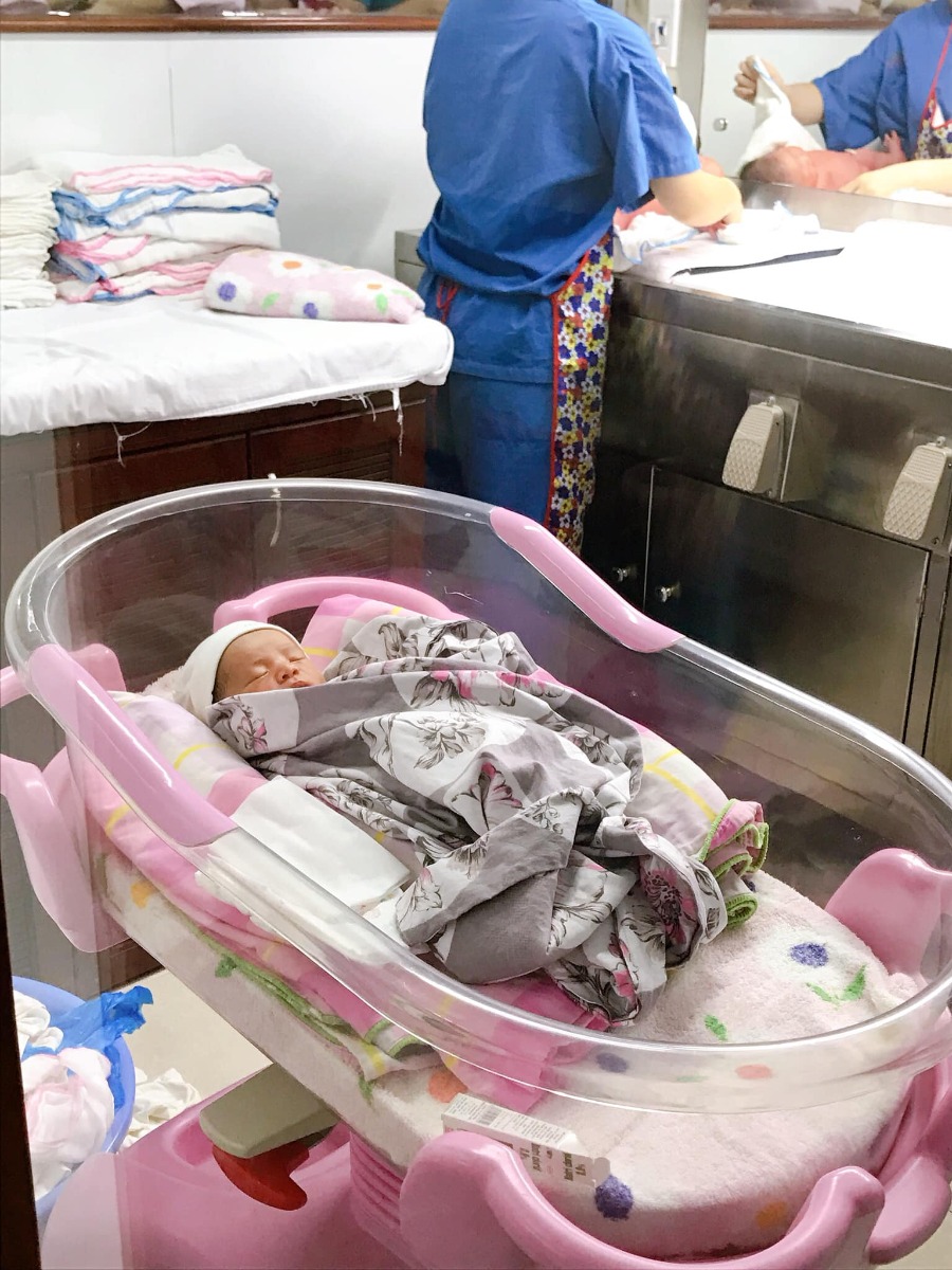 Review sinh mổ tại Hồng Ngọc -55 Yên Ninh, Ba Đình.

Sau rất nhiều lớp học tiền sản của các bệnh viện thì cuối cùng vợ chồng em quyết định sinh tại BV Hồng Ngọc. Em chia sẻ một số kinh nghiệm sinh cho các chị em bạn dì có ý định tham khảo:

TRƯỚC SINH:
- Lễ tân hướng dẫn lên tầng 13 vào phòng tư vấn có một bạn phụ trách sẽ giới thiệu chi tiết thủ tục và các gói để ba mẹ lựa chọn. Em đăng ký sinh khi 34 tuần. Đặt cọc 9tr.
- Trong gói mình có 5 lần: Xét nghiệm nước tiểu, siêu âm thai 2D. Và 1 lần: khám bsi gây mê, siêu âm 4D, xét nghiệm máu. Chạy máy Monitor và khám với bsi Sản khoa không giới hạn đến lúc sinh..... Do sát ngày sinh khám và siêu âm nhiều nên em siêu âm thêm ngoài gói 3 lần, 297k/lần. À một điểm cộng cho Hồng Ngọc là lần nào đến khám mình cũng được tặng 1 phiếu buffet dưới tầng 4. Đồ ăn k quá nhiều món nhưng sạch sẽ và dễ ăn. Còn người nhà thì gọi đồ riêng giá khá chát.
- Em đăng ký sinh thường nhưng đến sát ngày dự sinh mà không có cơn co, do nghe kinh nghiệm uống dứa ép với ăn rau ngót dễ sinh nên em uống 2 cốc dứa ép to chà bá. Sau đó bị rối loạn tiêu hoá nôn thốc nôn tháo, đau bụng, đi ngoài, mất nước). Vào viện trong tình trạng đau bền bỉ, âm ỉ và choáng váng. Cộng với việc thai trưởng thành vôi hoá hết bánh nhau, ối không còn trong do con đã biết ị và tiểu tiện. Nên bác sĩ chỉ định mổ ngay kẻo suy thai.

SAU SINH:
- 13h45p: Con đưa ra trao chồng em đón tay rồi y tá đưa đi theo dõi 3 tiếng. Bác sĩ tiếp tục khâu vết mổ của em đến 14h30 em được chuyển về phòng hậu phẫu theo dõi tiếp (cái phòng lúc đầu em vào mà em tưởng vào nhà xác ấy). 1 tiếng sau em bị tác dụng phụ của thuốc nên run bần bật, bsi tiêm một mũi là hết. Khi nằm liên tục có bác sĩ đến hỏi thăm và hướng dẫn mình theo dõi những bất thường sau mổ. 18h30 em được đưa về phòng.
- Khi về phòng hết thuốc tê thì đau kinh khủng khiếp các mẹ ạ. Em được truyền một chai giảm đau thì cũng đỡ. Hết thuốc thì sẽ được tiếp viên đút hậu môn.
- Ngày 2 em tiêm bắp 2 mũi và tiêm tĩnh mạch kháng sinh chống viêm vết mổ 2 lần. Từ ngày 3 chỉ tiêm kháng sinh 2 lần (đau và rất đau )
- Hàng ngày 3 lần với mẹ: Bác sĩ thăm khám. Y tá thay bỉm và vệ sinh mẹ
- Hàng ngày với con: Bác sĩ nhi khám con 2 lần. 9h sáng các cô y tá vào đưa con đi tắm và thay quần áo và bỉm cho con. Vệ sinh mắt mũi và rốn. Con được bệnh viện cho mượn thêm 1 bộ quần áo và khăn sữa sạch hàng ngày, được đổi liên tục.

QUÀ TẶNG
BV Tặng 1 bộ nous, 40 miếng bỉm Moony, Bình ti Chigo, 1 hộp sữa Hipp 300g, 1 chăn cuốn, trà lợi sữa, khẩu trang 1 lần, miếng lót thấm sữa, dầu gội đầu Chigo, giấy ướt Goon.
- Đầu giường bệnh có trang bị một nút chuông nhỏ, nếu cần y tá hỗ trợ thì bấm vào đó chưa đầy 10s sau sẽ có người đến hỏi mình cần gì. Nút này em bấm thường xuyên. Các em y tá khá nhiệt tình, lúc đầu thay bỉm cho con em cũng bấm 😉. Cây nước lọc nóng lạnh 24/24 ngay ngoài hành lang. Bệnh viện cho mượn máy hút sữa Avent nha các mẹ!

PHÒNG SINH
- Phòng theo gói 3 mẹ/phòng. Nhưng sợ ồn nên Chồng em đặt phòng riêng để người nhà lên chăm cho thoải mái. Thêm 1,2tr/ngày. Mọi người đến chơi cũng thoải mái. Phòng khép kín 2 giường, +1 giường gấp. Được 2 người nhà ở lại chăm. Có suất ăn cho người nhà 5 bữa/ngày. Phòng đủ tiện nghi: Tivi, tủ lạnh, tủ quần áo, bàn ghế tiếp khách, bình nước giữ nhiệt. Nhà vệ sinh full đồ, thêm cả khăn tắm, khăn mặt được thay và sấy tiệt trùng hàng ngày, bàn chải, kem đánh răng, dầu gội, sữa tắm, máy sấy (như khách sạn), thêm cả bỉm Caryn và 1 ấm nước pha sẵn Betadine để mình tự vệ sinh nếu cần. Nhân viên vệ sinh 2 lần/ngày: Dọn rác, cọ nhà vệ sinh, quét lau sàn, lau đồ đạc. Ga gối thay hàng ngày. Trong tủ đồ luôn sẵn quần áo thay cho mẹ, cho con và ga gối, mình có thể tự thay hoặc bấm nút gọi nhân viên đến làm.

ĂN UỐNG:
- 3 bữa chính (cơm, rau, món mặn, hoa quả tráng miệng) , 2 bữa phụ giữa sáng và chiều (chè, bánh, sữa), đêm 1 bát cháo móng giò hoặc sữa bò nóng. Đến giờ ăn có người mang lên tận phòng và dọn đi. Suất của người nhà cũng vậy nhưng không có ăn đêm. Hàng ngày có nhân viên lên giới thiệu thực đơc bữa sau cho mình và người nhà chọn món. Mẹ ck em khen bệnh viện nấu ngon nhưng vì quá đau nên em ăn chỉ cho có, chả thấy ngon hay không.

KHÁC:
- Chiếu đèn Plasma nhanh khô vết mổ 500k/lần là chi phí ngoài gói nha các mẹ. Em chiếu 2 lần hôm đầu và hôm cuối.
- Con đẻ xong được tiêm VitaminK ngay và trong 24h tiêm Viêm gan B.

XUẤT VIỆN:
- Cần chuẩn bị CMT bố mẹ và sổ hộ khẩu photo (có tên mẹ) để làm chứng sinh cho con. 1 bộ sơ sinh cho con và bộ mặc nhà cho mẹ khi xuất viện nha. Vì quần áo viện tặng là quần áo mới chưa giặt các mẹ ạ.
- Sinh mổ nằm viện 5 ngày 4 đêm. Tổng chi phí sinh nhà em hết khoảng 43 triệu. Trong đó BHYT nhà nước trả hơn 2 triệu. Còn lại là thẻ bảo hiểm bảo lãnh viện phí của 2 vc thanh toán (một số chi phí ngoài bảo hiểm thì mình phải tự chi trả nhưng so với dịch vụ mang lại thì cũng xứng đáng thôi ạ).
- Sau sinh 20 ngày em được hẹn quay lại khám mẹ và bé, tiêm Lao cho bé. Khám free, còn tiêm là 150k/mũi.

TÓM LẠI:
Do chưa đẻ bao giờ nên em cũng không biết các bệnh viện khác như nào mà so sánh. Còn theo đánh giá cá nhân em thấy sinh ở Hồng Ngọc khá ổn, chi phí hợp lý so với các bệnh viện quốc tế, nhân viên nhanh nhẹn, thái độ bác sĩ 5 sao, thái độ tá 4 sao, ăn uống 3sao, phục vụ 5sao. Đặc biệt các mẹ có bảo hiểm chế độ thai sản như em thì có thể tham khảo. Ở đây không nhận lót tay bác sĩ hay bồi dưỡng ekip mổ nên các mẹ yên chí. Bác sĩ mổ cho em còn đến thăm nom riêng mấy lần khá là tình cảm!

p/s: Sinh con mới hiểu lòng cha mẹ, tự nhiên đẻ xong ra nhìn thấy bà nội bà ngoại mà ứa nước mắt, thấy phụ nữ là thương và một lòng đồng cảm sâu sắc. Chị nào lại vớ được mấy anh chồng không biết chia sẻ mà tranh thủ lúc vợ bận con cái mà ra ngoài "giải nhiệt" thì thôi rồi. Không chỉ đau thể xác mà còn tan nát cả tâm can. Phụ nữ thật vĩ đại luôn ấy!

Dành cho các mẹ quan tâm!